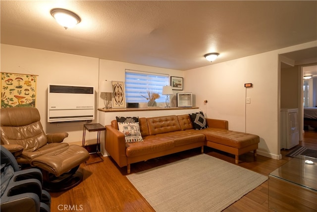 living room with a textured ceiling, heating unit, and hardwood / wood-style flooring