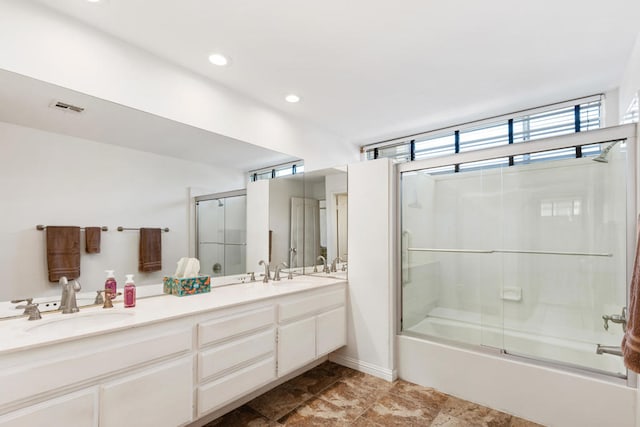 bathroom featuring vanity and bath / shower combo with glass door