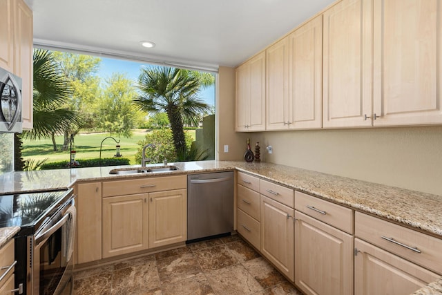 kitchen featuring light stone countertops, light brown cabinets, appliances with stainless steel finishes, and sink