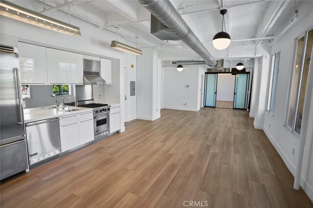 kitchen featuring sink, light hardwood / wood-style floors, high end appliances, and white cabinetry