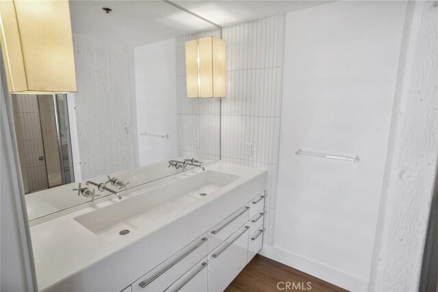 bathroom featuring vanity, baseboards, and wood finished floors