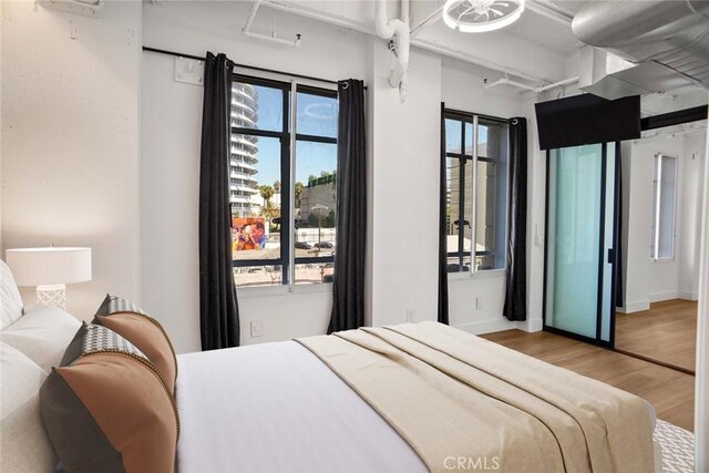 bedroom featuring hardwood / wood-style flooring and multiple windows