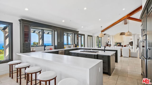 kitchen featuring vaulted ceiling with beams, decorative light fixtures, plenty of natural light, and kitchen peninsula