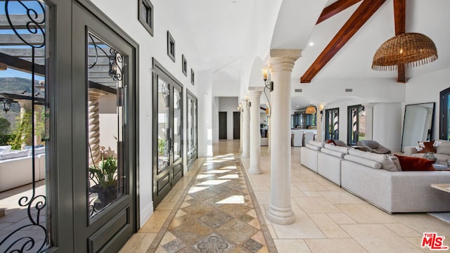 hall with french doors, decorative columns, and beam ceiling