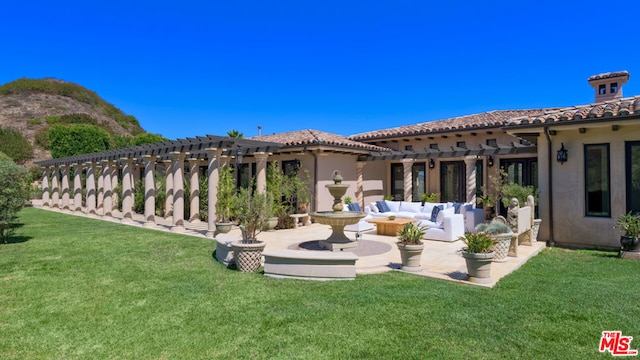 rear view of house featuring a pergola, a lawn, and a patio area