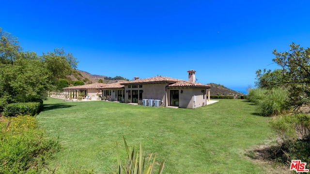 view of yard with a mountain view and central AC unit