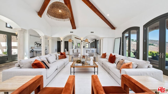 living room with decorative columns, beam ceiling, french doors, and high vaulted ceiling