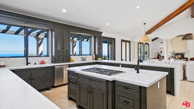 kitchen featuring hanging light fixtures, sink, a kitchen island, appliances with stainless steel finishes, and decorative columns