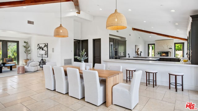 dining area featuring beamed ceiling and high vaulted ceiling