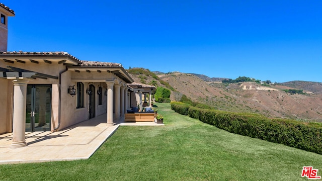 view of yard featuring a patio and a mountain view