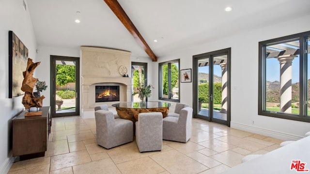 living room with a high end fireplace, vaulted ceiling with beams, and a healthy amount of sunlight