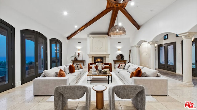 living room with decorative columns, beam ceiling, and high vaulted ceiling