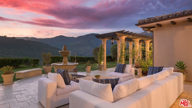 patio terrace at dusk with a mountain view, an outdoor hangout area, and a pergola