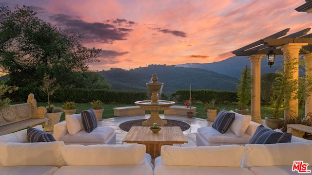 patio terrace at dusk featuring an outdoor hangout area and a mountain view