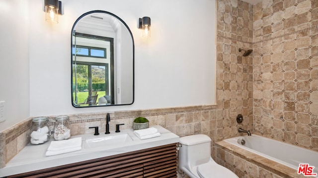 full bathroom with tiled shower / bath combo, vanity, and toilet