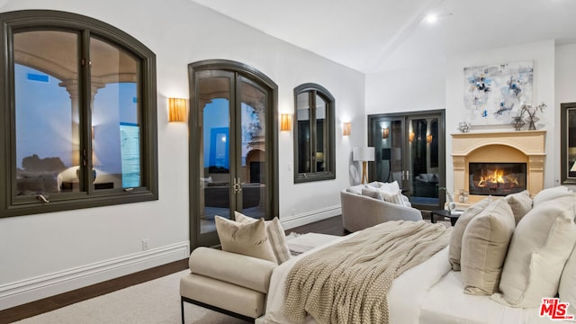 bedroom featuring vaulted ceiling, access to outside, and dark hardwood / wood-style flooring