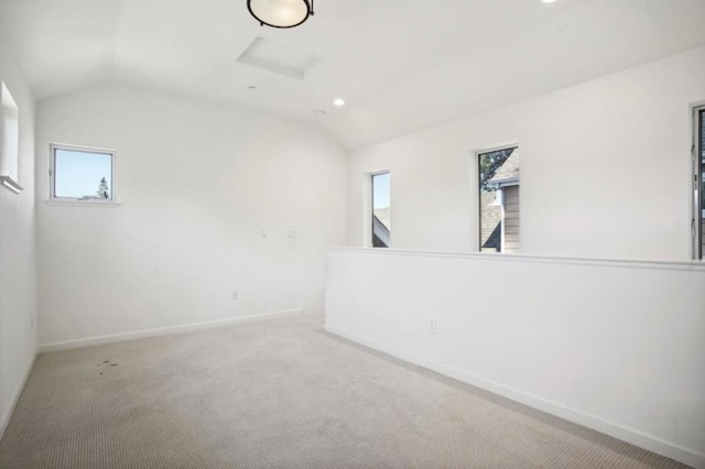 carpeted empty room with vaulted ceiling and a wealth of natural light