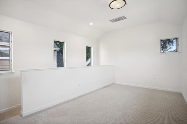 spare room with lofted ceiling and light carpet