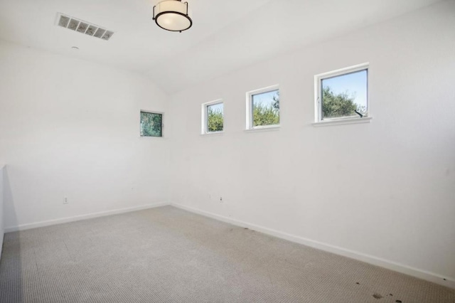 carpeted empty room with lofted ceiling