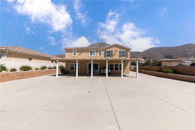 21047 Iron Rail Dr, Riverside, CA 92507 - mediterranean / spanish-style house with a patio, a mountain view, a fenced backyard, and stucco siding