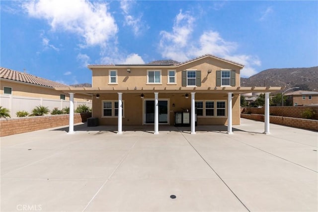 21047 Iron Rail Dr, Riverside, CA 92507 - back of property with ceiling fan, stucco siding, a fenced backyard, a mountain view, and a patio area
