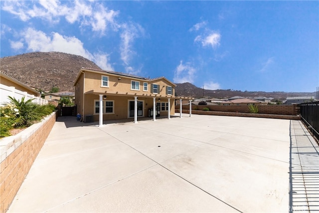 back of house with a mountain view and a patio area