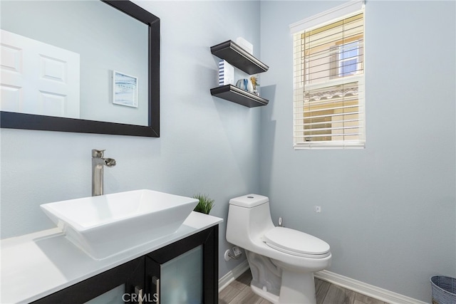 bathroom with vanity, toilet, and hardwood / wood-style flooring