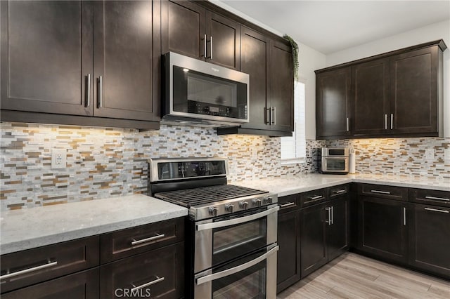 kitchen featuring light hardwood / wood-style flooring, tasteful backsplash, appliances with stainless steel finishes, and dark brown cabinetry