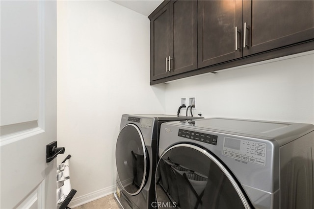 washroom with washing machine and dryer and cabinets