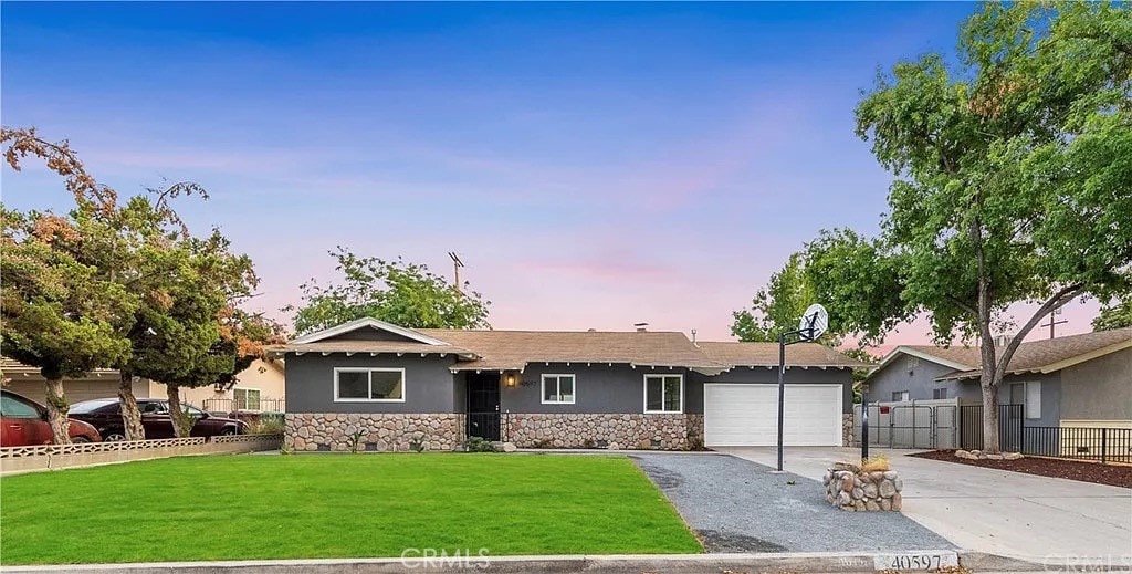 ranch-style home with a yard and a garage