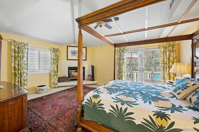 bedroom featuring a fireplace, multiple windows, and lofted ceiling