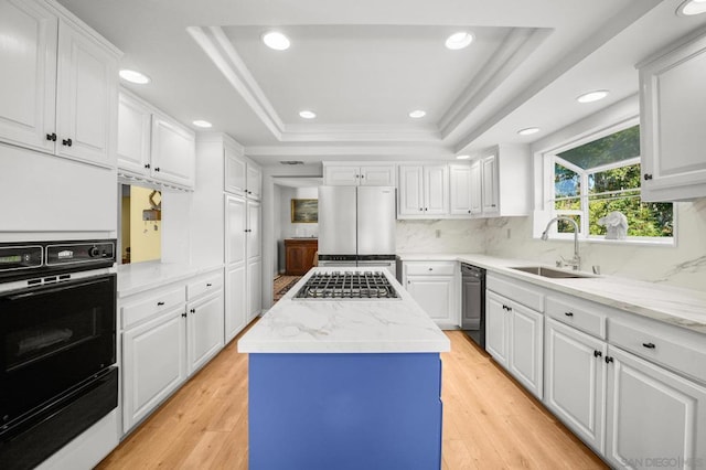 kitchen with white cabinets, a center island, and a tray ceiling