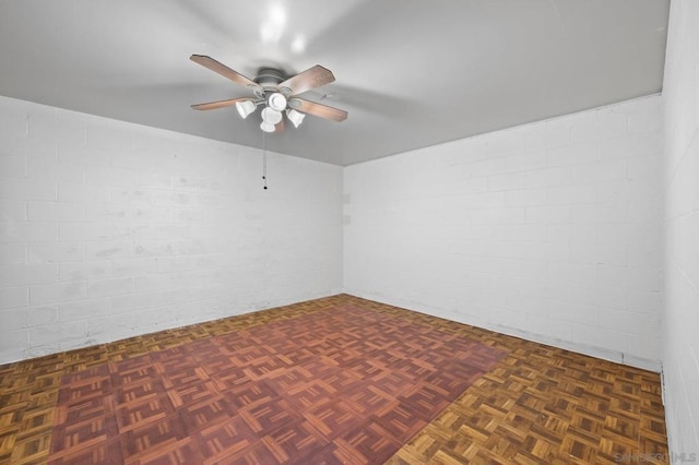 spare room with ceiling fan and dark parquet floors