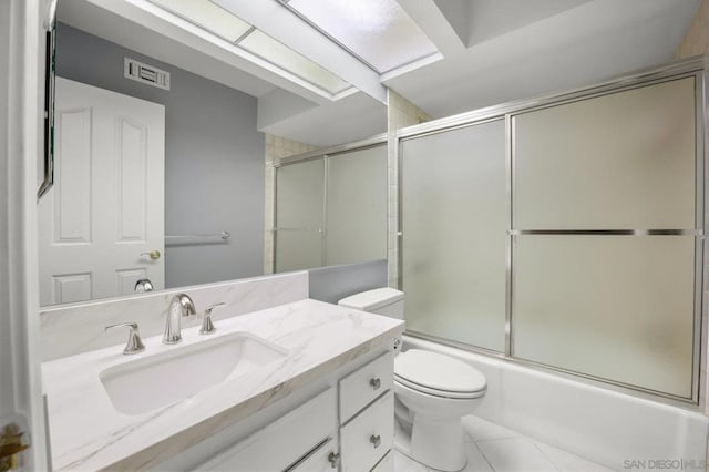 full bathroom with tile patterned floors, vanity, toilet, and enclosed tub / shower combo