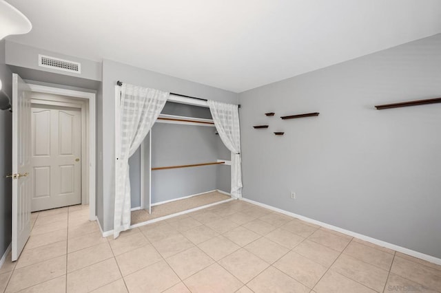 unfurnished bedroom with light tile patterned floors and a closet