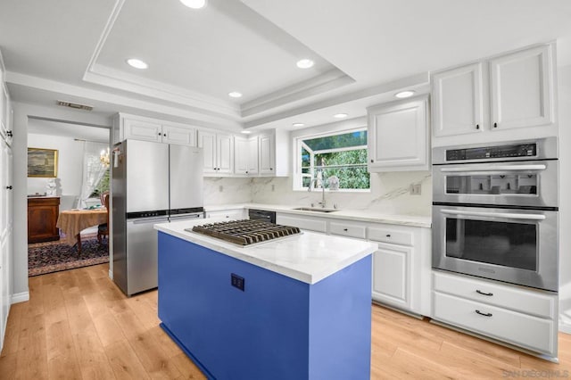 kitchen featuring white cabinetry, a kitchen island, light hardwood / wood-style floors, and appliances with stainless steel finishes