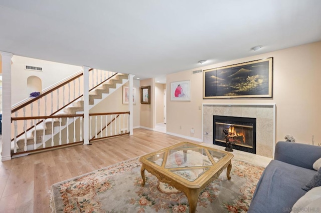 living room featuring a tile fireplace and hardwood / wood-style flooring