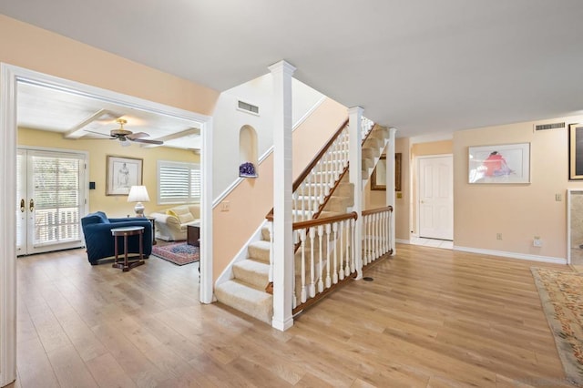 stairs with hardwood / wood-style flooring and ceiling fan