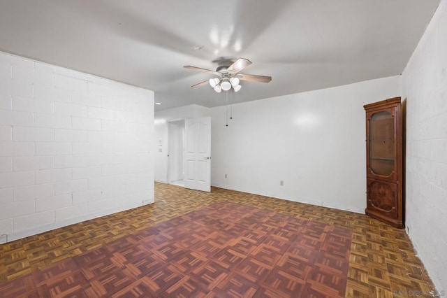 unfurnished room with dark parquet flooring and ceiling fan