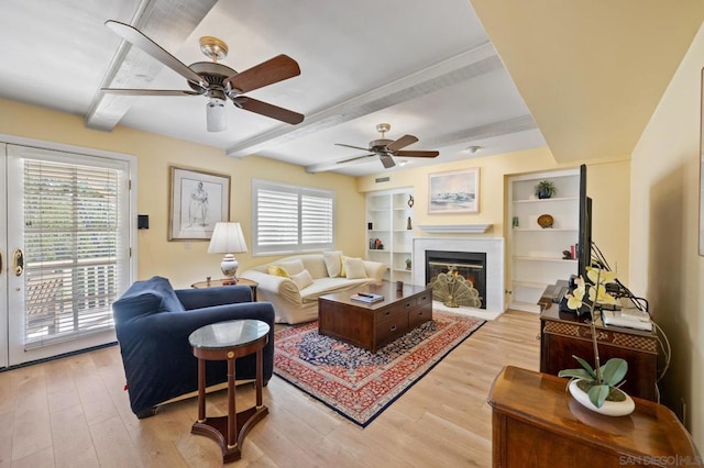 living room featuring beamed ceiling, light hardwood / wood-style floors, plenty of natural light, and ceiling fan