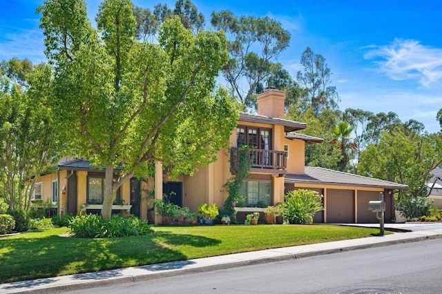 view of front of home with a balcony and a front lawn