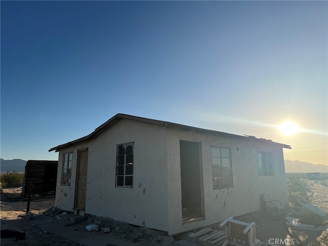 property exterior at dusk with a mountain view