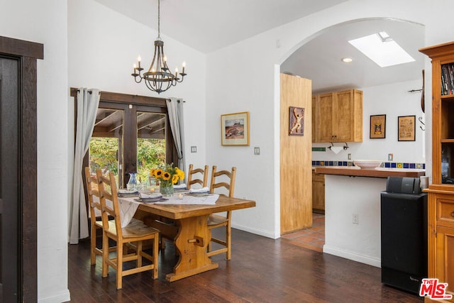 dining area with french doors, dark wood-type flooring, and a notable chandelier