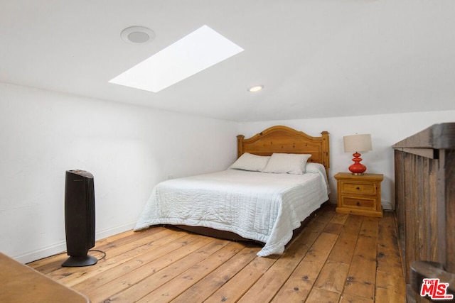 bedroom with a skylight and hardwood / wood-style flooring