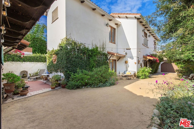 rear view of property with a patio and a storage unit