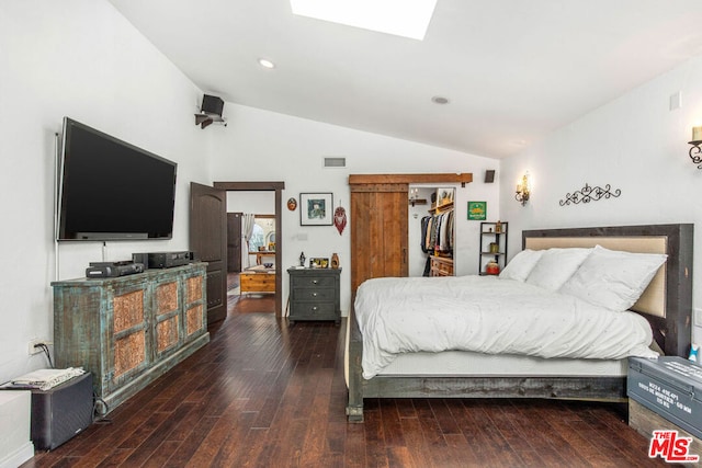 bedroom with a closet, dark wood-type flooring, and vaulted ceiling with skylight