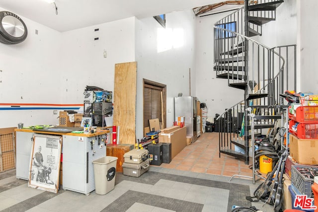 interior space with a workshop area and stainless steel refrigerator