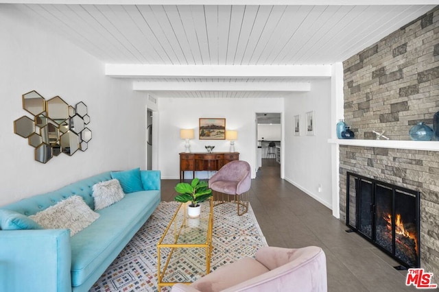 tiled living room featuring beamed ceiling and a fireplace