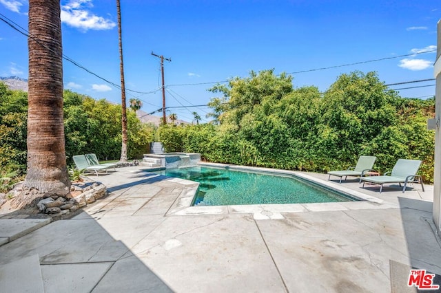 view of swimming pool featuring a patio and an in ground hot tub