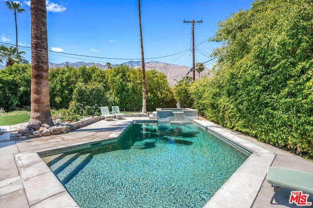 view of pool featuring a patio and an in ground hot tub